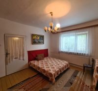Bedroom in a family house with a decorative chandelier, curtains, and carpet.