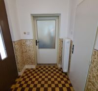 Tiling with a checkerboard pattern in the interior of a family house with white walls.