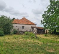 A family house in Dulovce with a large yard and garden, surrounded by trees.