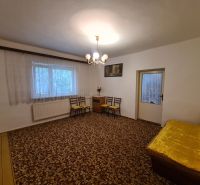 Living room in a family house with a carpet and a yellow sofa.