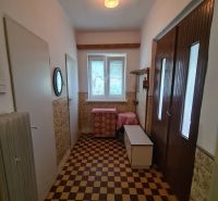 A hallway with tiles in a family house, light source, storage space, radiator.