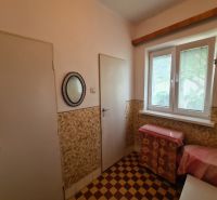 Interior in a family house with a tiled floor and a window with blinds.