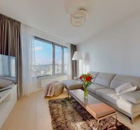 Living room with a sofa and a television, wooden decor flooring, 3-room apartment.