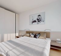 Bedroom with a bed, sliding wardrobes, and a painting, 3-room apartment with wood-patterned flooring.