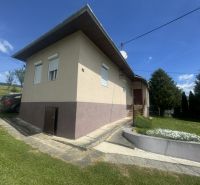 A family house in Orlov with a driveway, a car, and a landscaped garden.