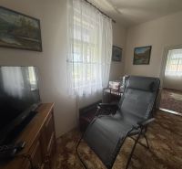 Living room in a family house with a TV, an armchair, and decorations on the walls.