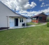 A family house in Orlov with a grassy garden and a gazebo under the blue sky.