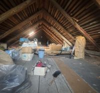 The attic of a family house filled with various items, including cardboard boxes.