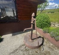 A family house in Orlov with an old water pump on a gravel base.