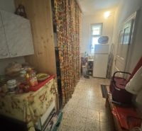 A hallway in a family house with colorful curtains and kitchen furniture.