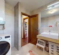 Bathroom in a 3-room apartment with tiles, a sink, and a washing machine with storage space.