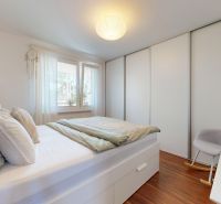 A bedroom with a bed, built-in wardrobe, and wooden decor flooring in a 3-room apartment.