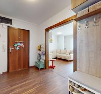A hallway in a 3-room apartment with a wooden decor floor and a built-in wardrobe.