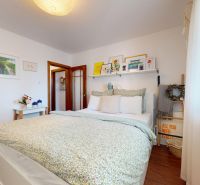 A bright bedroom with decorations and a wooden decor floor in a 3-room apartment.