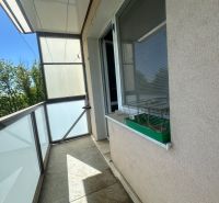 A balcony with tiles and railing in a 2-room apartment.