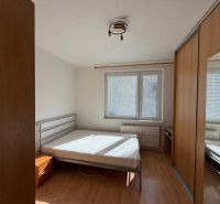 Bedroom in a 3-room apartment with a bed and built-in wardrobe, floor with wooden decor.