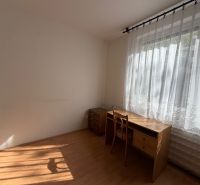 A room with a desk and a chair, a wooden-patterned floor.