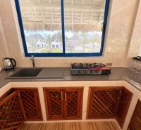 A kitchen in a family house with a gas stove and a view of the grounds.