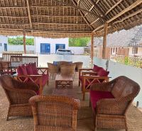 A covered terrace with rattan furniture in Zanzibar offers a family house a pleasant place to relax.