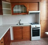 A kitchen in a 3-room apartment with a wooden decor kitchen unit.