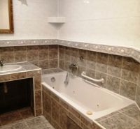 A bathroom with tiles and a bathtub in a 3-room apartment.