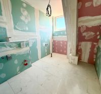 Bathroom in a 2-room apartment with preparation for installation, the floor is waiting for final finishing.