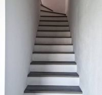 A staircase with a wooden decor floor leading upwards in a family house.