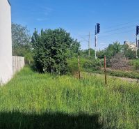Courtyards of family houses on Hviezdoslavova Street in Senec, separated by a railway track.