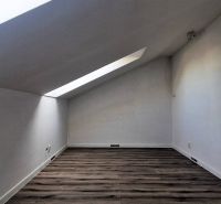 Attic room with wooden decor flooring in a family house.