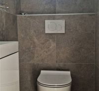 A toilet with ceramic tiles in a family house.