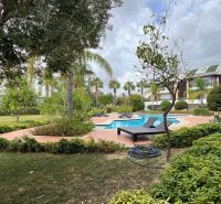 A pool surrounded by greenery and loungers in a garden in Side, Turkey, for Special Properties.