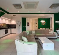 Living room with a sofa, kitchen, dining area, and white furniture in a unique property.