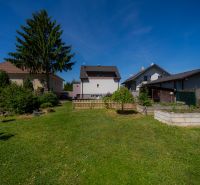The garden of a family house on Jahodova Street in Trencin with a lawn and trees.