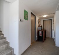 Entrance hall of a family house with a wooden decor floor and a staircase.
