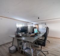 Office room in a family house with a wooden decor floor and work desks.