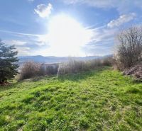 Green plot in Azalkova, Banska Bystrica surrounded by nature and blue sky.