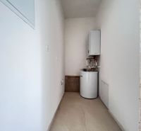 Technical room in commercial premises with a boiler and a tank-mounted heater.