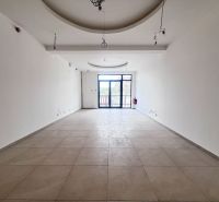 Interior of a commercial space with a window and white walls.