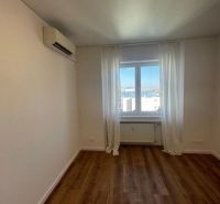 A room in a 3-room apartment with a wooden decor floor, air conditioning, and a window with a view.