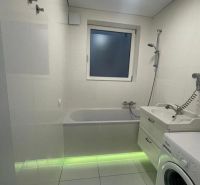 White bathroom in a 3-room apartment with a bathtub and a washing machine.