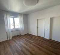 A room with a wooden floor decor, white walls, and curtains in a 3-room apartment.