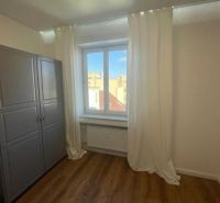 A room in a 3-room apartment with white curtains and a floor with a wooden decor.
