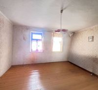 An empty room in a family house with a wooden decor floor and a floral chandelier.