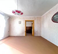 A room in a family house with a decorated chandelier and a floral pattern on the wall.