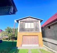 Family house in Žirany with a brick garage and wooden decor in the garden.