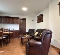 The interior of the villa with wooden floor decor, leather furniture, and a tiled stove.