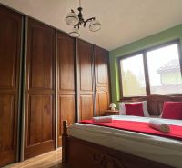 Bedroom in a villa with a large wardrobe, bed, painting, and wooden decor.
