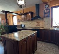 The villa's kitchen with wooden decor, floor with wooden design, spacious windows.