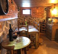 A wine cellar with brick walls and a wooden table in a villa, wine on the table.