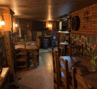 A villa with a cozy wine cellar, brick walls, barrels, and rustic wooden furniture.